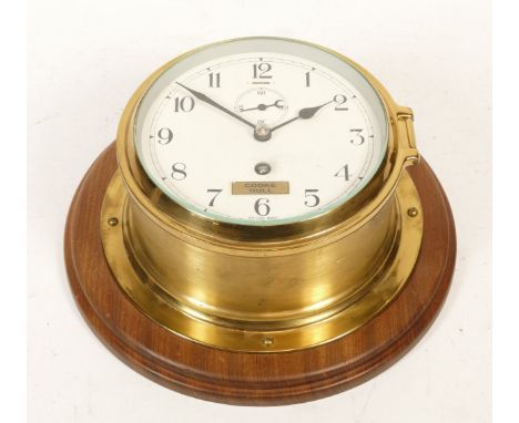 A brass bulkhead clock, having painted dial with Arabic numerals and subsidiary second dial with British manual wind movement