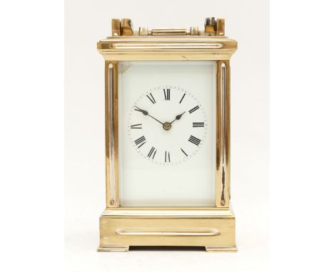 A brass carriage clock, white enamel dial with Roman numerals, the unsigned movement striking the half and hours on a gong, 1