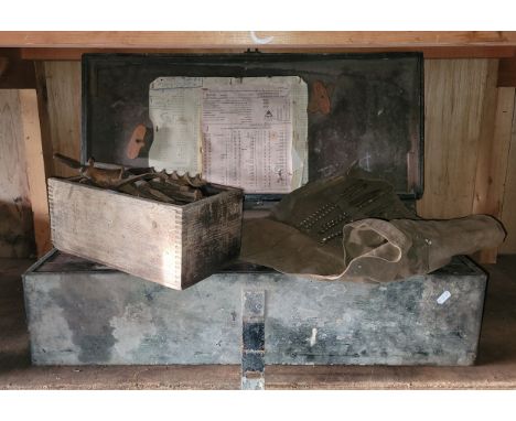 A wooden tool box containing a selection of carpentry tools, a collection of auger drill bits within a cloth cover and a coll