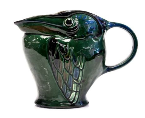 C H Brannam, an Art Pottery grotesque pelican jug, 1910, relief moulded, majolica glazed in green with loop handle, incised m