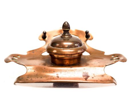 A Jugenstil copper ink stand, sinuous form with reticulated borders, the turned lid opening to reveal a ceramic liner, 16cm w