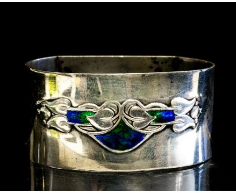 Archibald Knox for Liberty, a silver and enamelled napkin ring, Embossed Art Nouveau stylke foliate design with blue green en