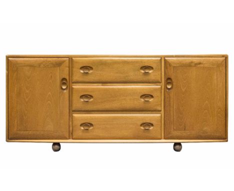 An Ercol Windsor sideboard, light elm and ash, three drawers flanked by cupboards, on caster feet, 156cm wide, 70cm high, 44c