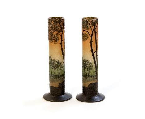Legras, a pair of French Art Nouveau etched and painted glass vases, cylindrical form with coical feet, depicting a riverside