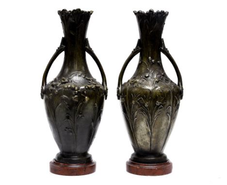 After Moreau, a pair of French Art Nouveau style cast bronzed vases on marble bases, daisies and lily of the valley, one with