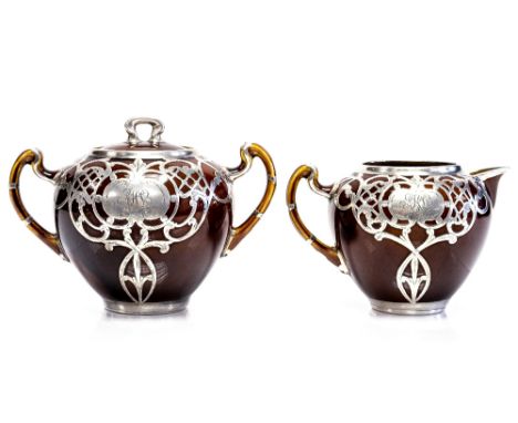 An Art Nouveau silver overlaid brown glazed milk jug and matching sugar pot, circa 1905, the bases each stamped 'Sterling 560