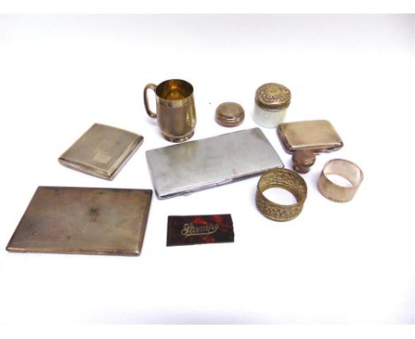 A SILVER NAPKIN RING ; a silver circular watch box with an engine turned pull off cover; and three silver cigarette cases; 39