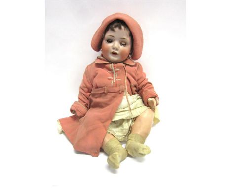 A GERMAN BISQUE SOCKET-HEAD DOLL with a cropped brown wig, sleeping brown glass eyes, and an open mouth with two upper teeth,