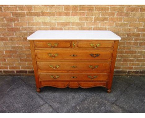 A CONTINENTAL MARBLE TOPPED COMMODE fitted with two short and three long drawers with cast gilt metal rococo handles on turne