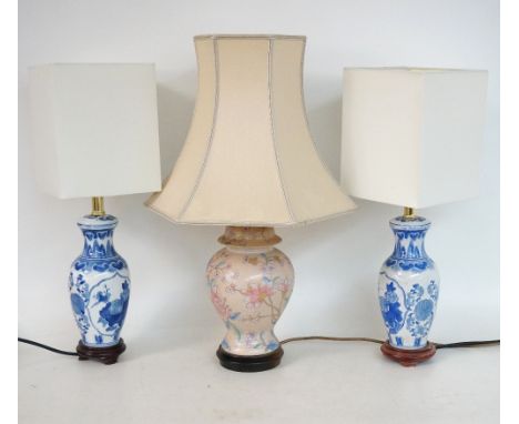 PAIR OF CHINESE POTTERY TABLE LAMPS
decorated with blue and white flowers and birds, and a pink ground lamp with floral decor