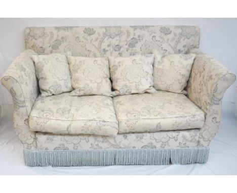 TWO SEAT SOFA
with shaped arms, in a pale fabric with floral motifs, with four loose cushions, on castors, 172cm wide 