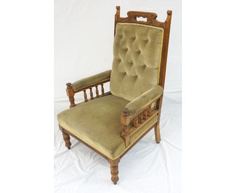 LATE VICTORIAN OAK FRAMED ARMCHAIR
with shaped carved top, button back, railed padded arms, in golden green fabric, raised on