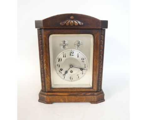 GERMAN BRACKET CLOCK
in an oak shaped case with a glass door with turned columns, the silvered chapter ring with Arabic numer