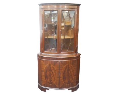 MAHOGANY CORNER DISPLAY CABINET
with a moulded dentil cornice above a pair of glazed doors enclosing a shelved interior above