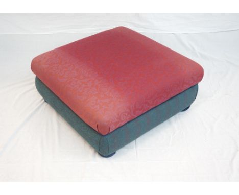LARGE SQUARE POUFFE
covered in red and contrasting red and green material, standing on four bun feet, 77cm wide  