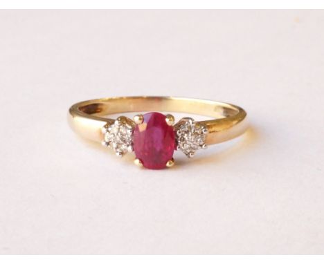 RUBY AND DIAMOND CLUSTER RING
the central oval cut ruby flanked by diamond clusters to each side, on nine carat gold shank, r