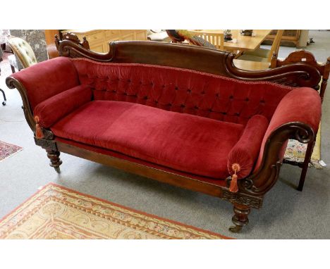 A Victorian Carved Mahogany Scroll End Sofa, on turned baluster supports on brass castors, 209cm by 62cm by 108cm