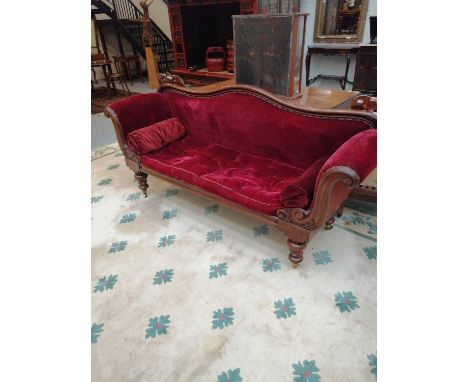 A Victorian Carved Mahogany Scroll End Sofa, on turned baluster supports on brass castors, 213cm by 52cm by 99cm