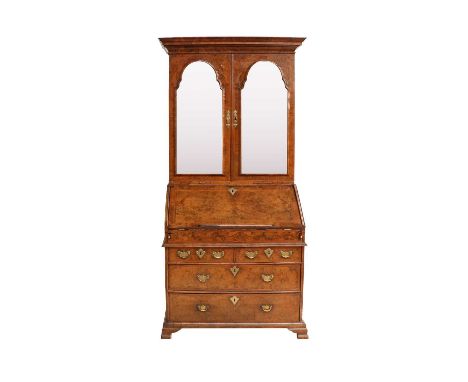 A George I Burr Walnut and Featherbanded Bureau Cabinet, early 18th century, the cavetto cornice above bevelled glass mercury