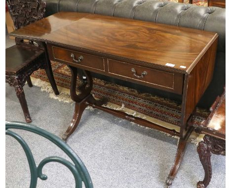 A Regency Style Mahogany Sofa Table, with brass paw feet moving on castors, 140cm by 50cm by 76cm