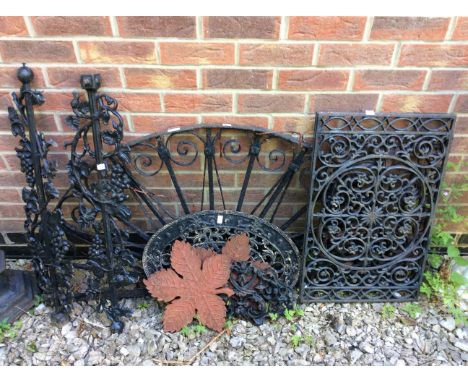 A collection of ornate cast iron items to include grate or vent covers with other decorative items.