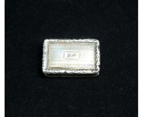 A George IV silver vinaigrette, of rectangular shape, ribbed body, cast foliage edge and engine turned geometric designed cov