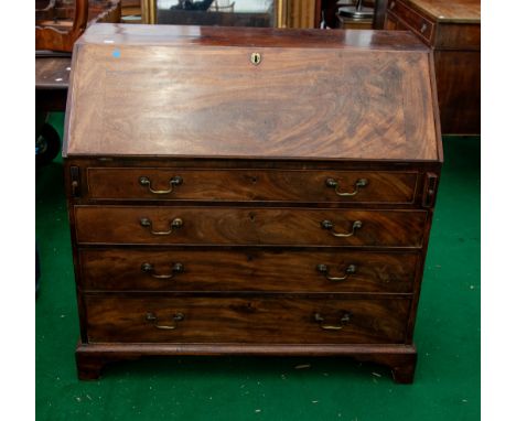 A George III mahogany large slopefront bureau, opens to reveal fitted interior pigeon holes and drawers, above four long grad