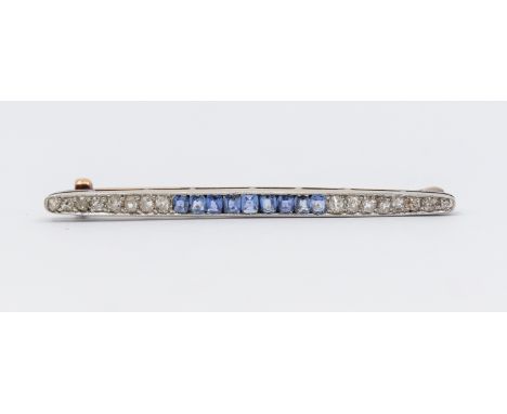 A sapphire and diamond 9ct gold brooch, comparing a central channel set row of cushion cut sapphires, grain set either side w