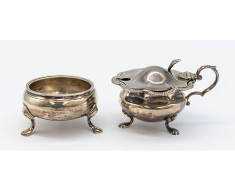 A late Victorian silver mustard pot, of stylised shape with curved ribbed edge and scrolled handle, with blue glass liner, ha