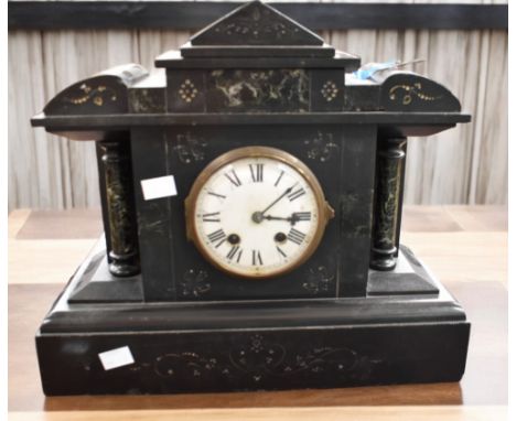 A late 19th Century French black slate 8 day mantle clock with round enamelled dial and Roman numerals.