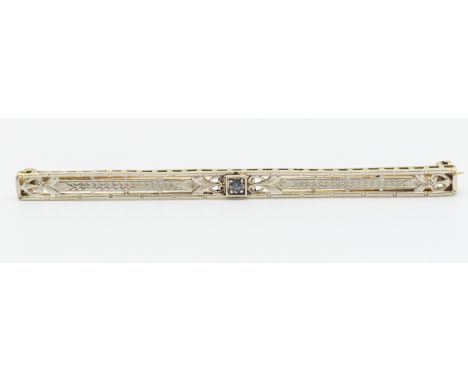 A sapphire set platinum and yellow metal bar brooch, set to the centre with  a small sapphire, within a platinum border of en