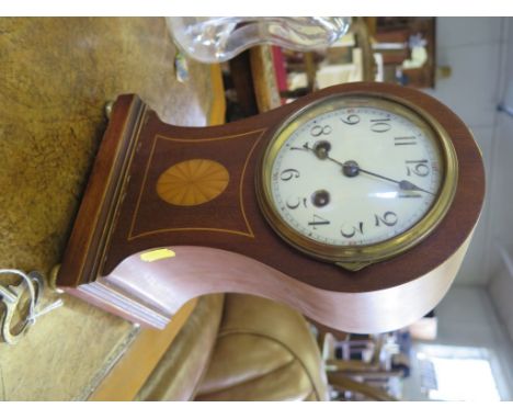 An Edwardian mahogany mantel clock, of arched waisted form with inlaid patera and enamel dial, twin train French movement str