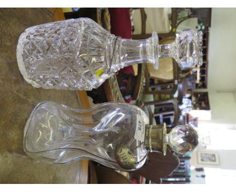 A glass decanter with a silver collar and a silver wine label for sherry together with a second decanter with a silver wine l