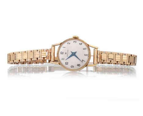 HAMILTON, NINE CARAT GOLD CASED MANUAL WIND WRIST WATCH, the round dial with Arabic hour markers, on a nine carat gold bracel