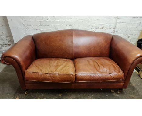 A Laura Ashley brown leather two seater sofa with scrolled arms. IMPORTANT: Online viewing and bidding only. Collection by ap