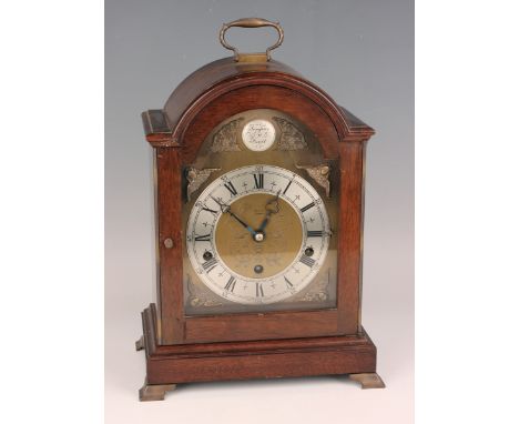 A mid-20th century George III style mahogany mantel clock with eight day movement chiming on gongs, the brass breakarch dial 