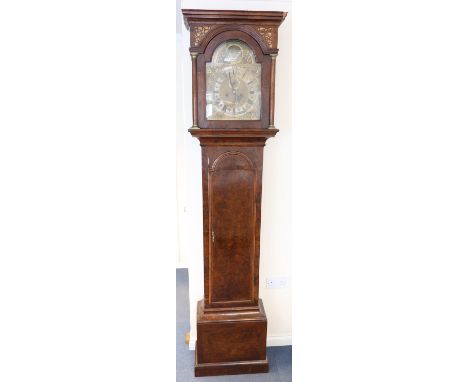 An early 18th walnut longcase clock with eight day movement striking on a bell, the 12-inch brass breakarch dial with silvere