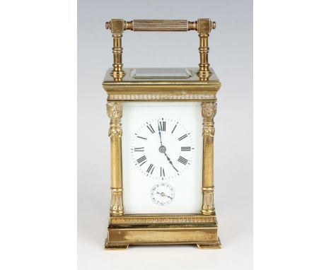 An early 20th century brass cased carriage alarm clock with eight day movement striking on a gong, the white enamelled dial w