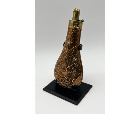 A 19th century copper and brass powder flask on stand by G & J W Hawksley with embossed decoration of oak leaves, stag and fo