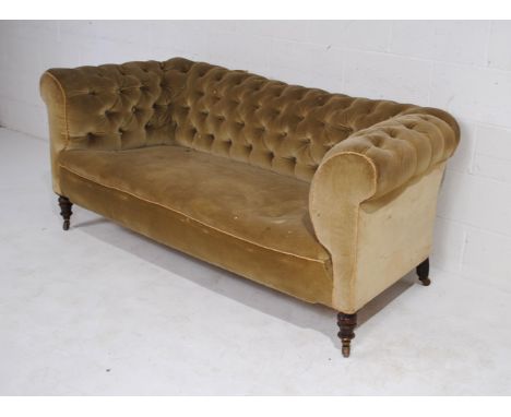 A two-seater button back chesterfield settee, needs upholstering, on turned legs and ceramic castors.180 cm wide, 84 cm deep,