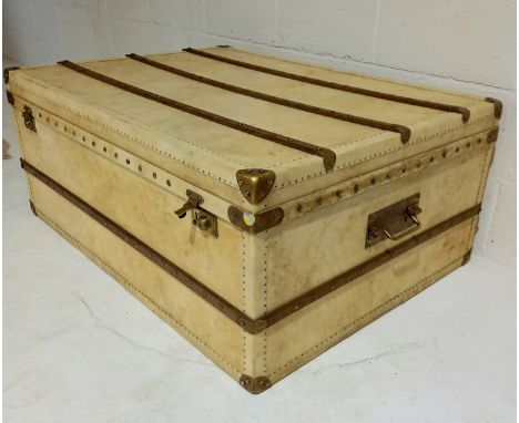 A large vintage cabin trunk, in a cream vellum, with oak and brass stud decoration, (slight splitting to back) 110cm wide, 80
