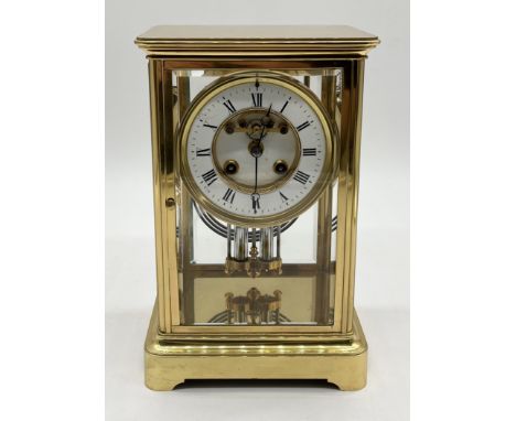 A 19th century brass four glass mantel clock, the circular dial set with Roman numerals and mercury pendulum