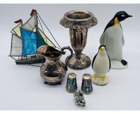 A Poole Pottery penguin with one other similar, along with a small selection of silver plated items including a vase, jug, co