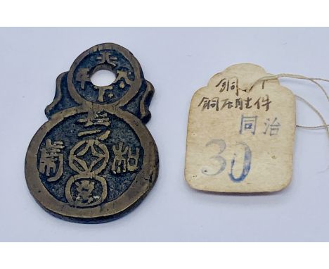 A Chinese bronze pendant charm with paper tag with seal