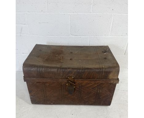 A large metal trunk with leather strap