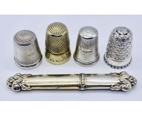 A continental silver needle case circa 1860 along with three silver thimbles and one other