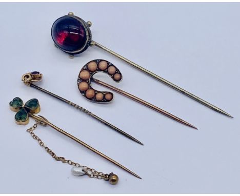 Two 9ct gold stick pins along with two others- the coral horseshoe interspersed with diamonds