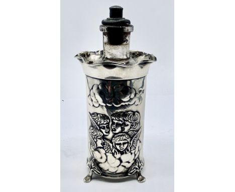 A scent bottle in hallmarked silver sleeve decorated with cherubs