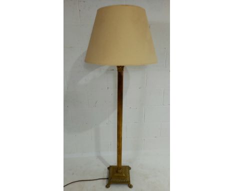 A vintage brass Corinthian column standard lamp with parchment shade.