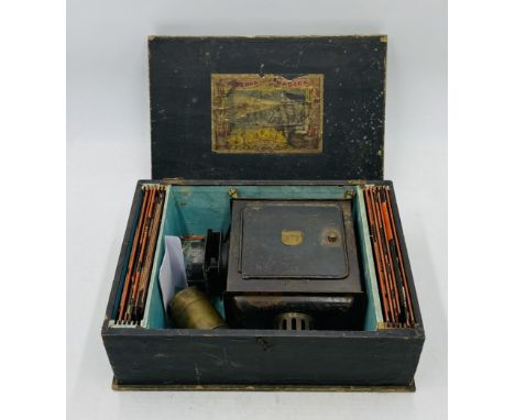 A boxed German Gegrundet child's magic lantern with coloured slides depicting nursery scenes - some slides A/F